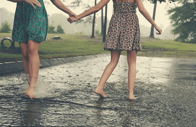 Irmãs de mãos dadas na chuva