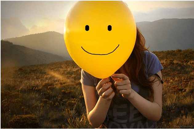 Menina exibe um balão com um sorriso